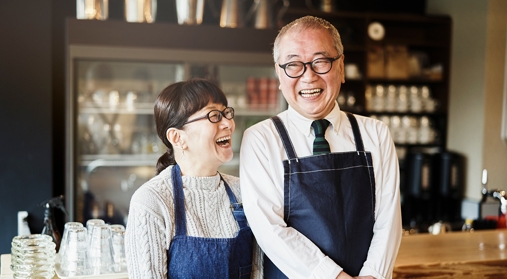 Store owner smiling in store doorwar